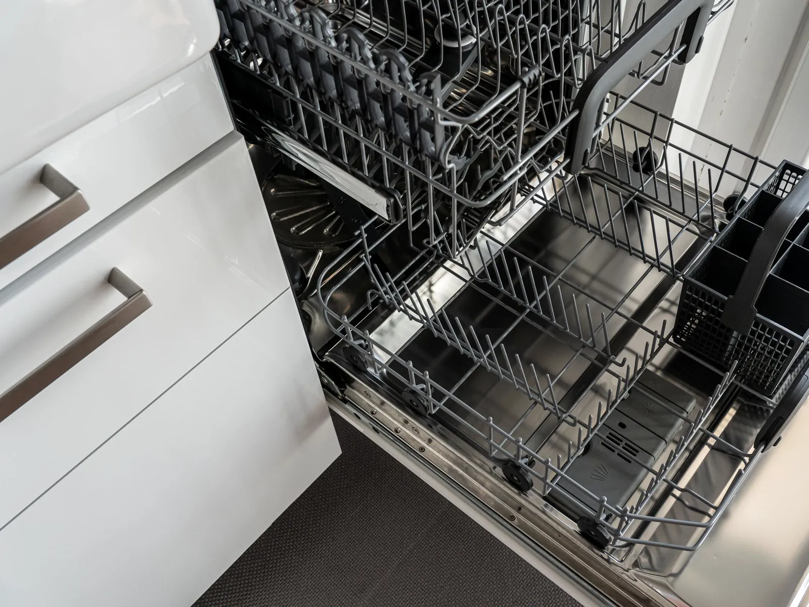 Open built-in dishwasher with empty racks