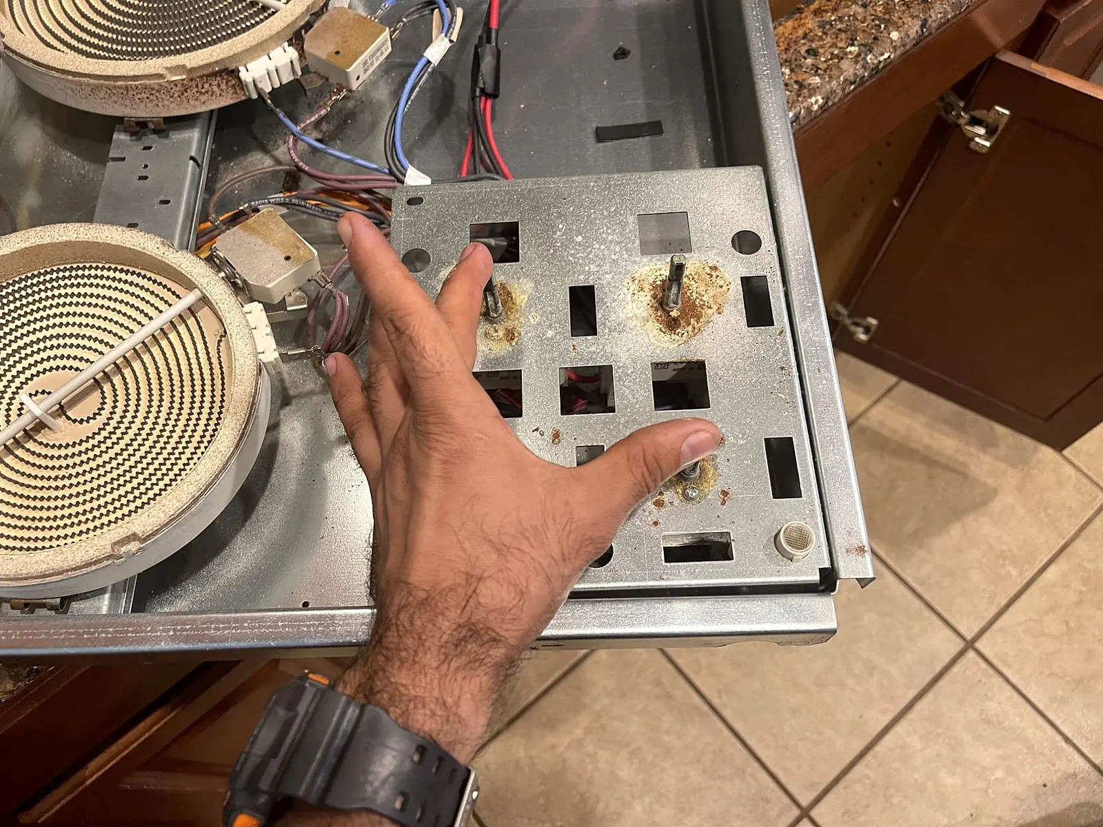 Radiant electric cooktop opened up, with two heating elements and the control switch plate exposed
